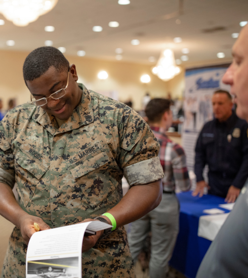 A Marine reviewing opportunities at a Hiring our Heroes Job Fair